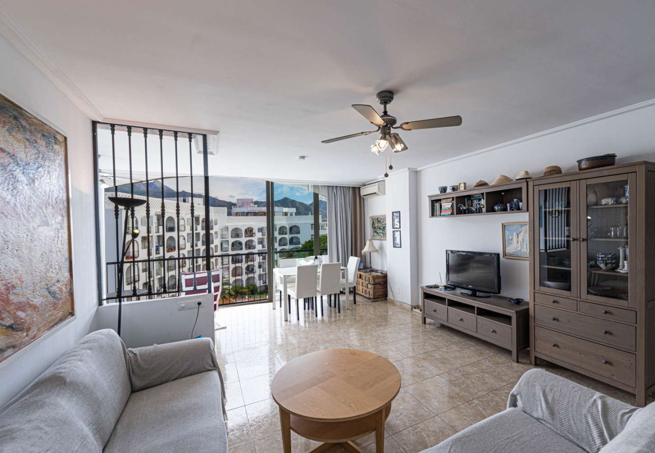 Bright living room with sofa and television in holiday rental apartment for 4 people in Nerja