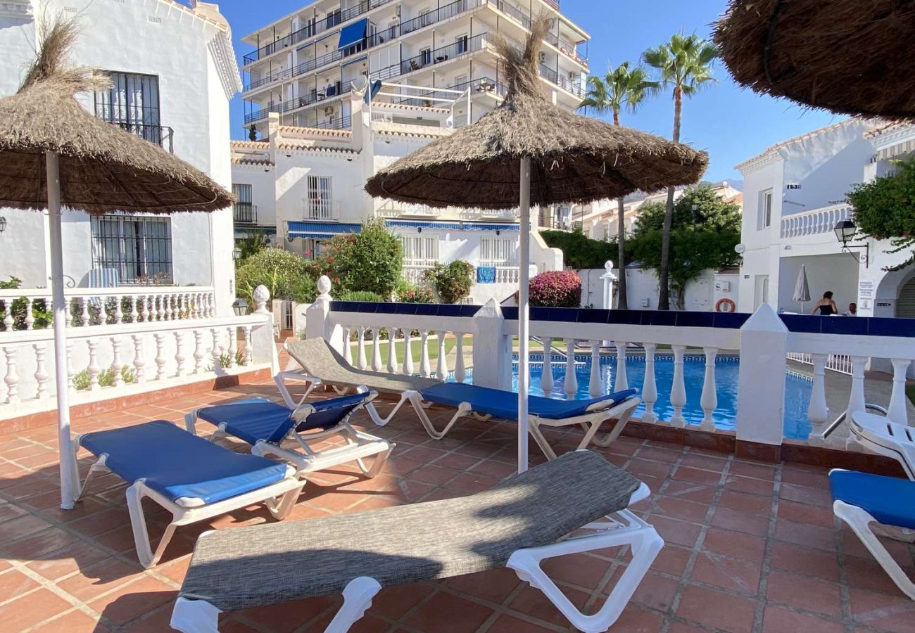 Sun loungers and umbrellas by the pool area in Nerja residence