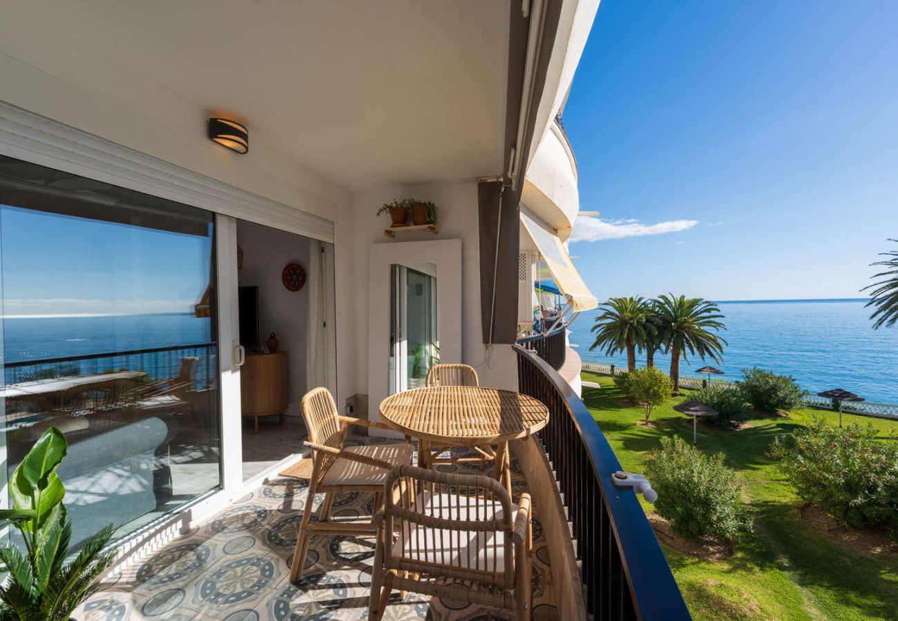 Balcony of the accommodation with sunny skies and views of the sea and garden