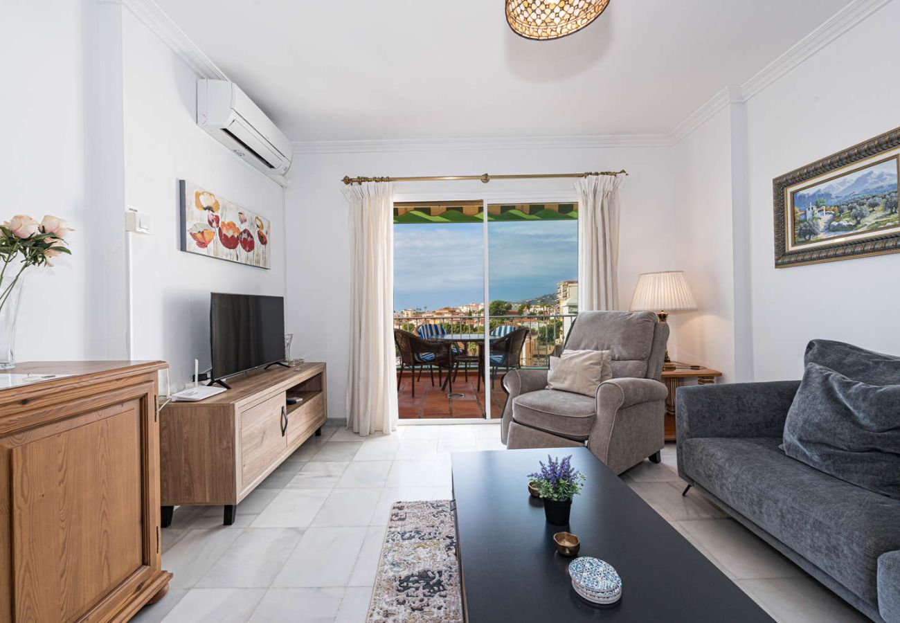 Bright living room with comfortable sofa and direct access to the sea-view balcony.