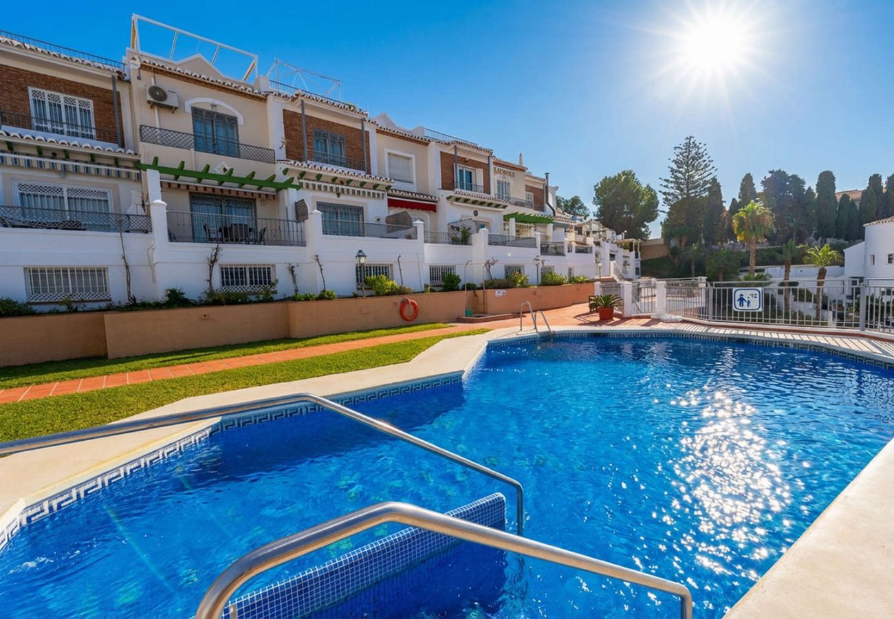 Communal swimming pool surrounded by the Andalusian-style townhouses of the complex.