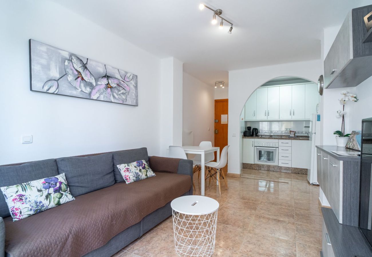 Open-plan living-dining area with integrated kitchen in Nerja holiday apartment.