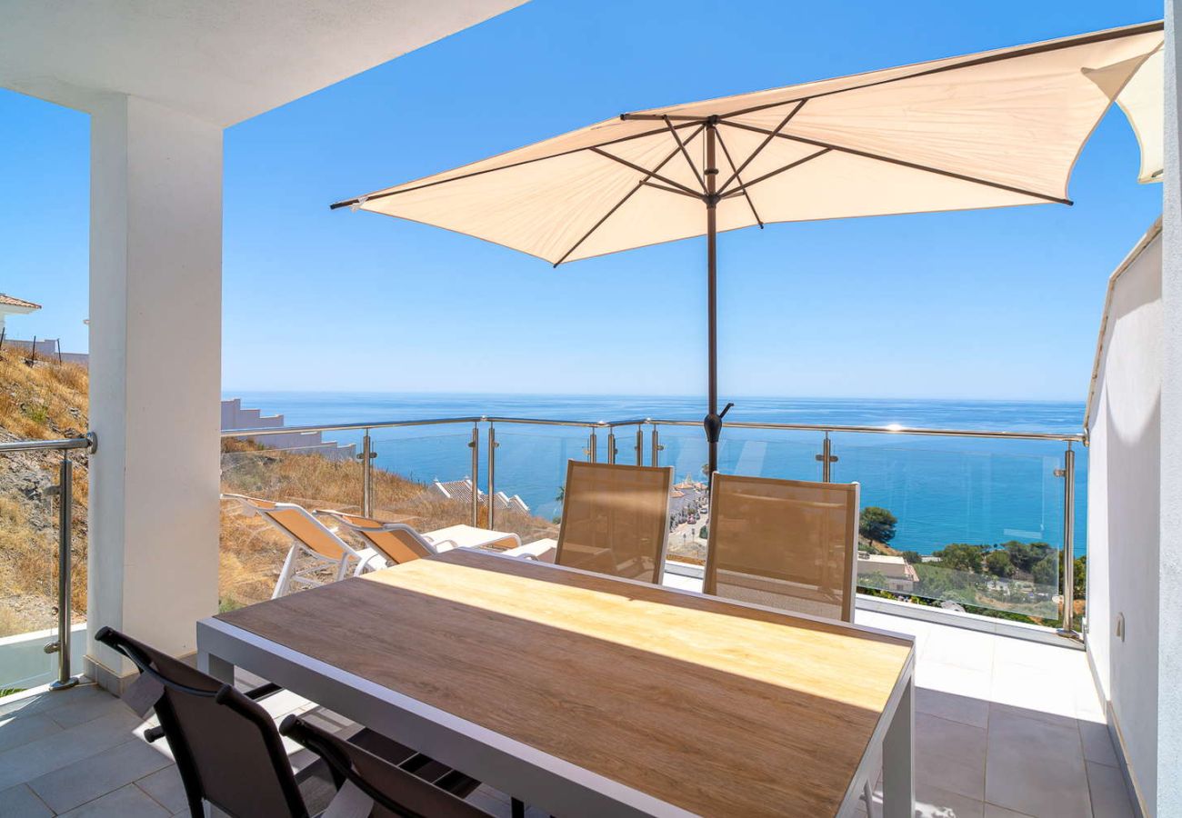 Private terrace with dining table and panoramic Mediterranean views on a sunny day in Nerja.