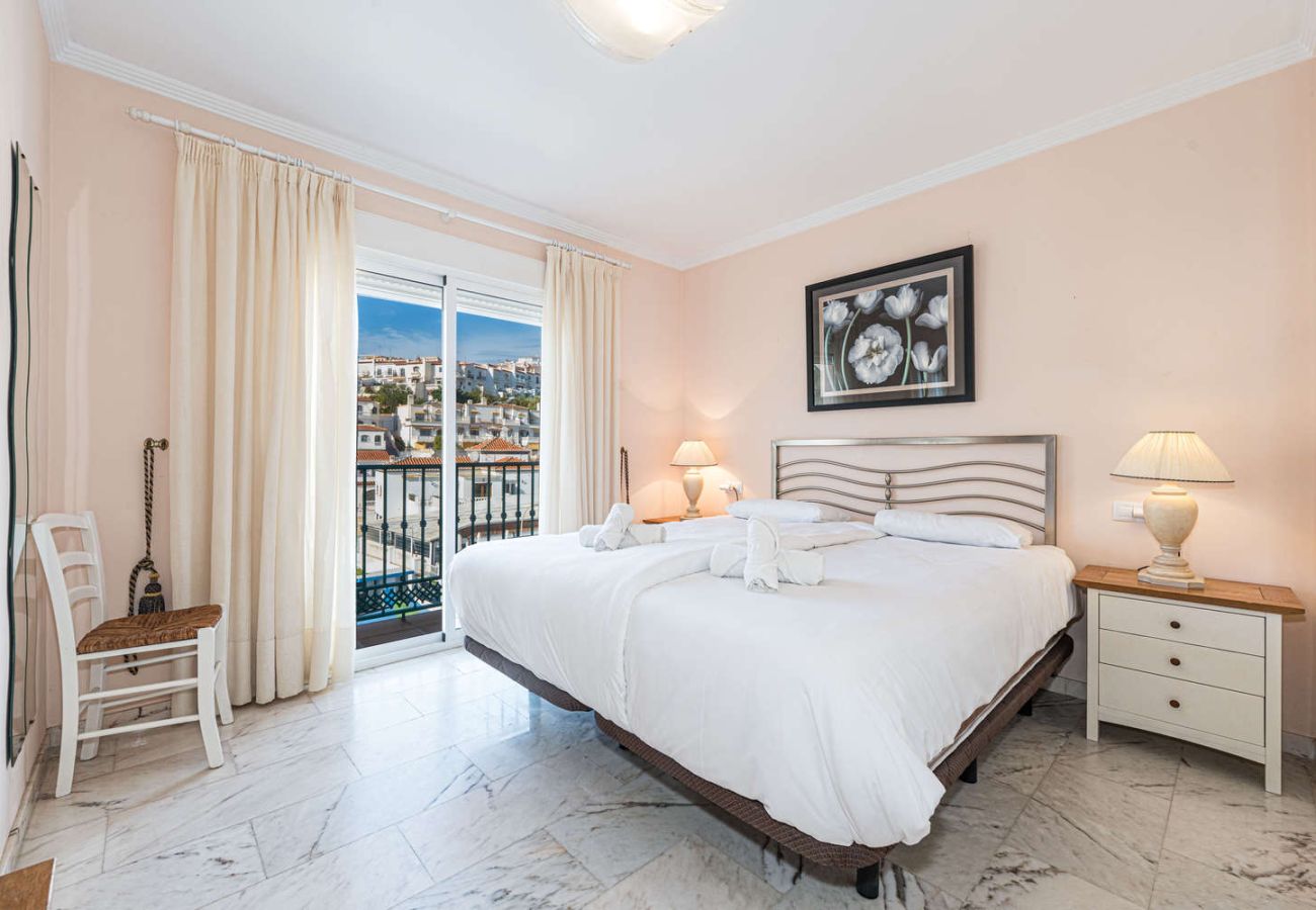Master bedroom with double bed and private balcony near the beach in Nerja.
