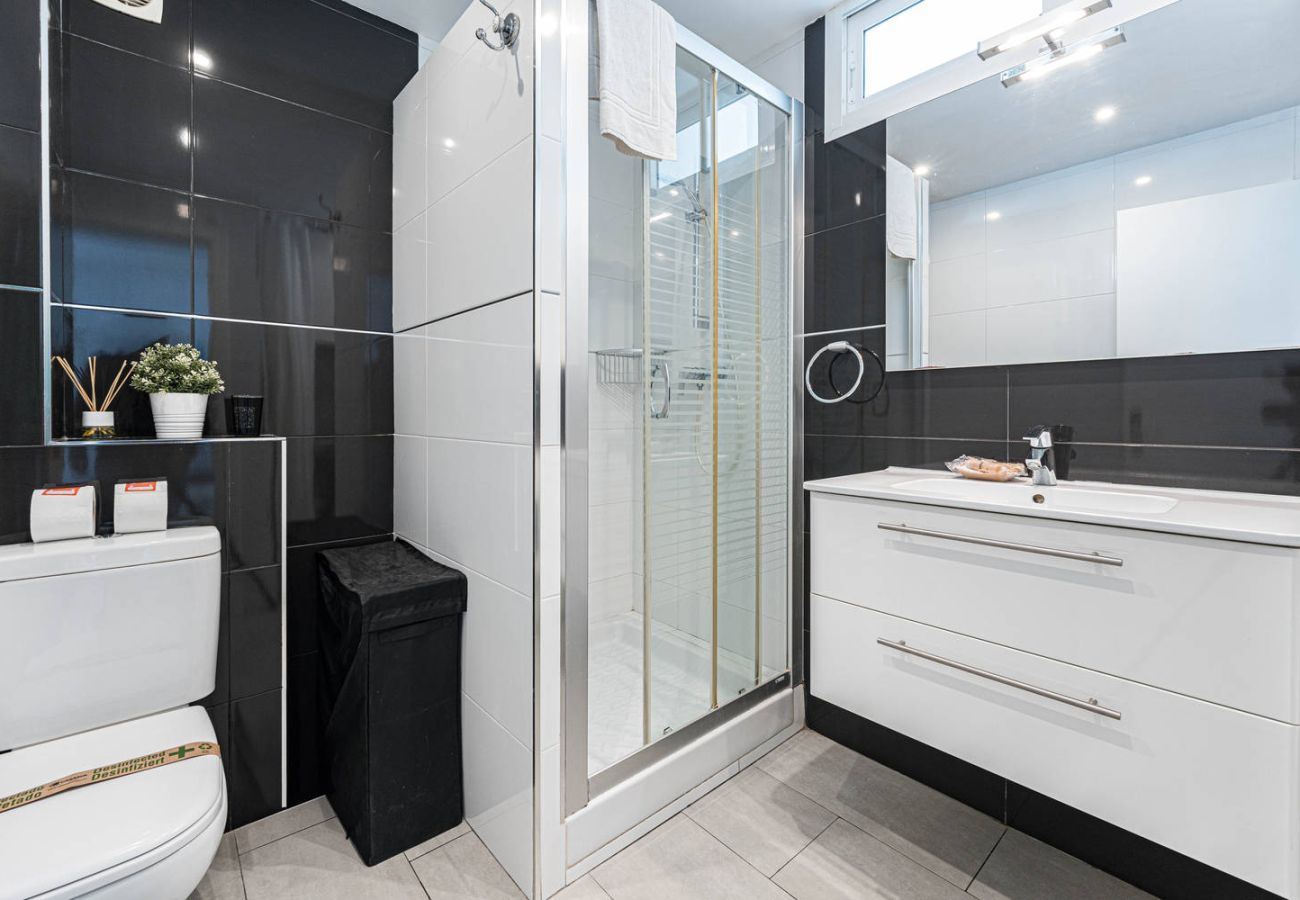 Bathroom with shower and washing machine in holiday apartment