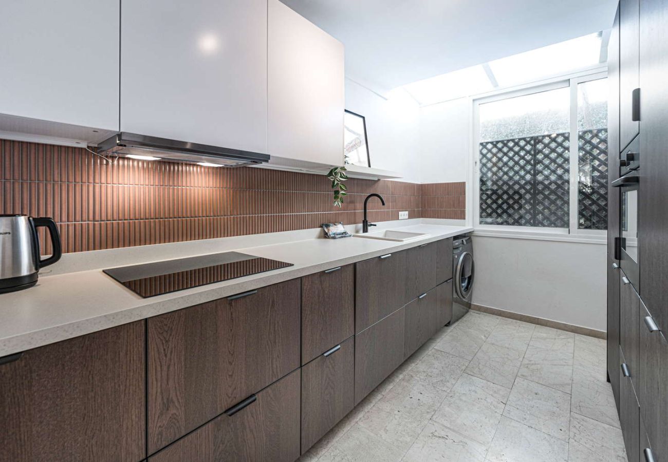 Fully equipped modern kitchen with oven, microwave and stylish design in holiday accommodation.