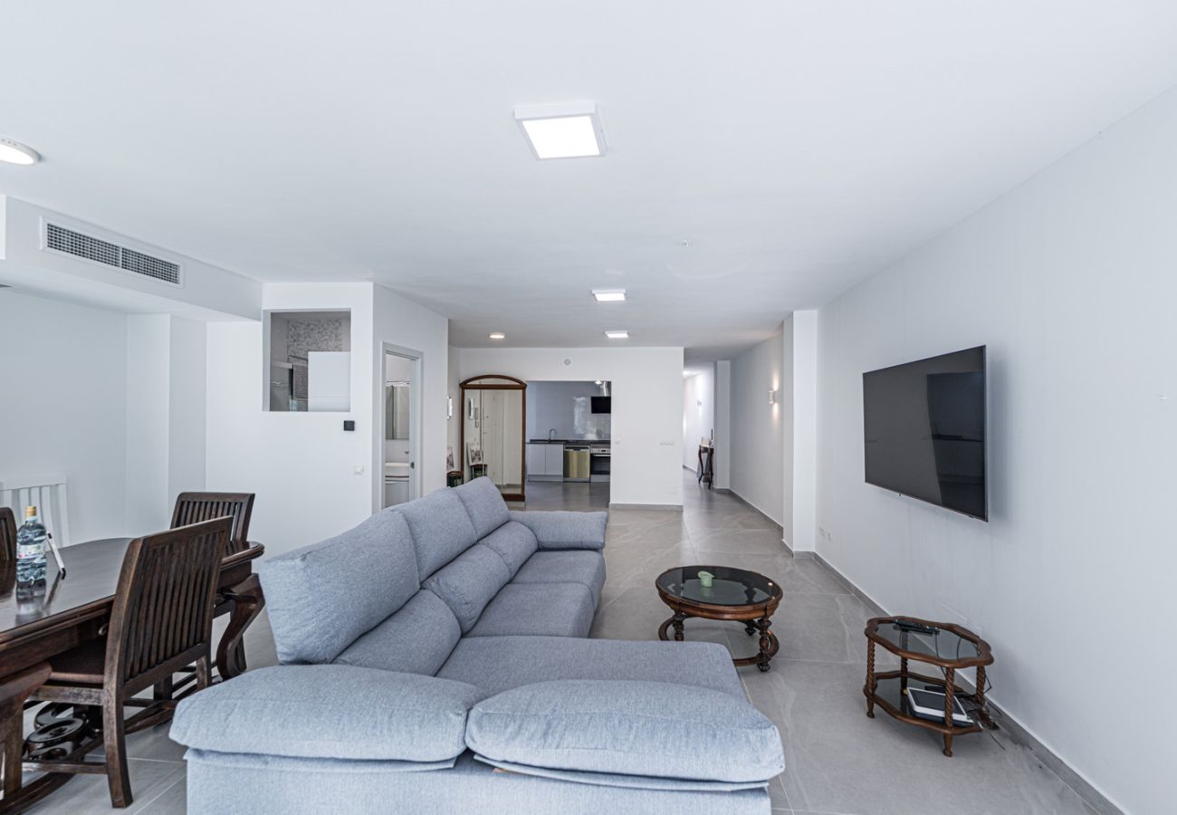 Bright and spacious living room with sofas and TV in Nerja town centre apartment.
