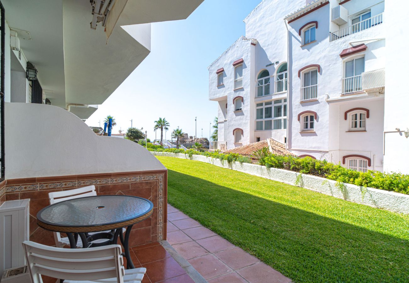 Entrance terrace of Arce 2 apartment with table and chairs facing the communal garden.