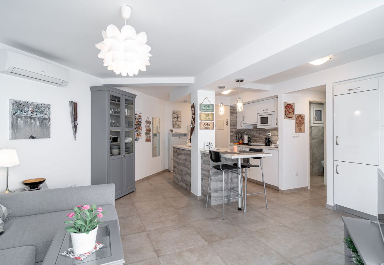 Översikt över det moderna vardagsrummet och köket med öppen planlösning i Nerja centrum.