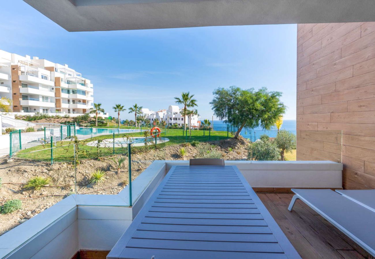 Privat terrass med solstolar och panoramautsikt över havet och poolen på Isea Calaceite Nerja Torrox