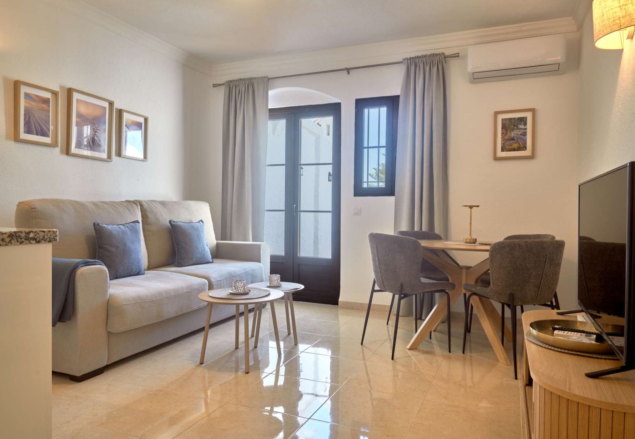Modernt vardagsrum med soffa, matplats och luftkonditionering i lägenheten Casa Sofia, Capistrano Village.